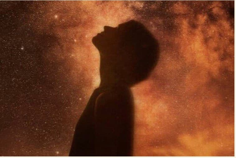A figure looking up at the cosmos